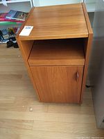 Front view of cabinet with door closed and open shelf above.