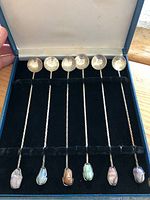 Set of six spoons with twisted handles and coin bowls inside a blue velvet box