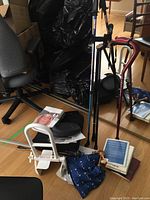 Wide view showing walking canes, walking pole, tub safety rail, cushion, and miscellaneous items on floor.