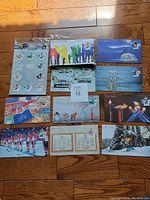 Full set of 10 Canada 150 Day of Issue envelopes laid out neatly on a wooden floor, featuring various Canadian-themed illustrations and photographs.