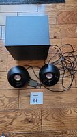 Full set of Creative Labs MF8480 2.1 speakers including subwoofer and two satellite speakers shown on wooden floor with cables visible.