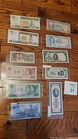 Overview image of 11 international bank notes arranged on the floor, showing a variety of designs and denominations.