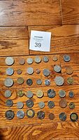 Top-down image of all 42 coins displayed on wooden surface showing their scale and detail.