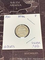 Front side close-up of a 1941 Newfoundland 10 cents silver coin showing the denomination 10 cents inside a wreath design on a circular coin.
