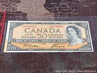 Front side of the 1954 Canadian $50 banknote showing Queen Elizabeth II portrait and serial number.