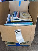 Top view of one box filled with assorted books showing titles and spines.