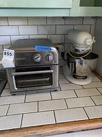Both toaster oven and stand mixer on tiled countertop, showing size and condition.
