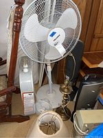 Wide shot showing the collection of fans, heaters, and lamp clustered together with a wood backdrop.