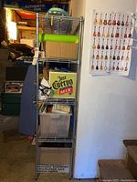 Photo showing full view of four-shelf metal wire rack with various boxes and items stored on the shelves.