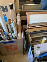 Two cardboard boxes side by side containing rolled and flat posters, canvas prints and art tubes