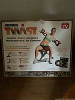 Front view of the AB Doer Twist exercise machine box with model demonstrating exercise.