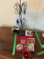 Jewelry tree stand holding earrings and a blue pendant, various bangle bracelets and jewelry boxes with assorted costume jewelry items including pins and earrings.