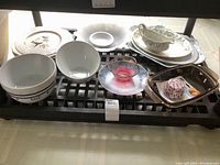 Photo of assorted dishes including bowls, plates, pink glass sauce dish, metal tray