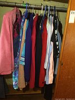Photo showing several garments hung including the pink leather jacket on the left end.