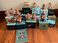 Group photo of 10 hand painted Pen Delphin rabbit figurines of various characters placed on their original boxes with 'Barney' book in front