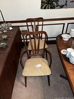 Two chairs side by side, front view showing frames, arms, backs and seats