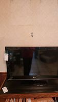 Front view of LG 32" flat-screen TV on stand showing screen and front bezel with LG logo.