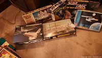Overview of 4 model kits including Cutty Sark wooden ship, Star Trek Next Generation models, Santa Maria ship, and Space Shuttle Power Satellite model.