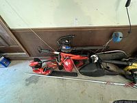 Photo showing multiple yard power equipment including chainsaw, hedge trimmers, and blower arranged on garage floor against wall.