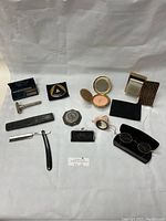 Overview photo showing all items in lot, including multiple makeup compacts, pouches, eyeglasses, razors and cases, woven coin holder, and embroidered mail clip case.