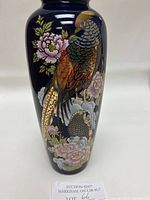 Photo of the vase front showing cobalt blue surface with detailed gold and colored birds and flowers.