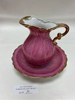 Pink mini water pitcher with gold trim and matching base plate on neutral background