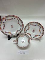 Full view of the three Mintons porcelain items: teacup, saucer, and dessert plate displayed with a lot number card