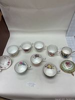Complete view of all 10 English teacups arranged in a semicircle to show patterns and shapes