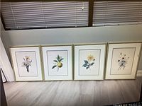 Four framed botanical prints by P. J. Redoute, gold frames, arranged side by side showing various flowers with cream matting.