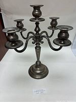 Front view of silver candelabra showing five arms and central stem with noticeable tarnish.