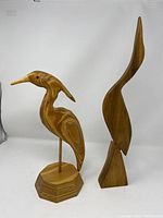 Two wood bird carvings, one signed by Jack Taylor, both standing upright on bases, showing front and side views.