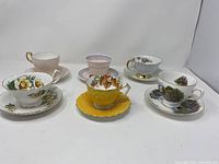 All six teacup and saucer sets shown together, showing variety of patterns and colors