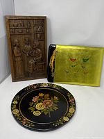 Wood carved plaque alongside lacquer photo album and metal tray, showing entire lot
