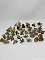 Top and front view of 44 Wade animal figurines arranged on a white surface showing variety in animals and colors