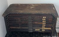 Top and front view of oak printer chest showing 9 drawers with brass pulls and number tags