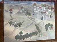Detailed view of the hanging rug tapestry depicting rolling hills, houses, and trees in woolen weave