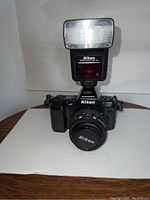 Nikon AF N8008 35mm camera with Speedlight SB-24 flash mounted, front view showing lens and flash.