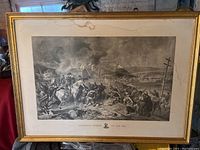 Framed black and white print showing a Civil War scene titled 'Sherman's March to the Sea' with soldiers and burning buildings, mat and frame visible.