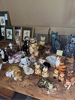 Top view showcasing the collection of different ceramic cat figurines arranged on a wooden table.