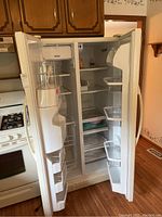 Front of the refrigerator with both doors open, showing the interior shelves, door bins, and compartments including the freezer and fresh food sections.