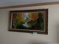 Frontal view of the large original landscape painting featuring a river and autumn trees, showing the full frame and the painting's colors.