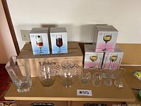 Photo showing all glassware and vases arranged on tabletop including boxed goblets, clear vases, and large box with Calgary Hockey glasses