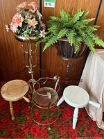 Image showing two artificial plants and five plant stands, various wood and metal styles and finishes, multiple small stools and pots.