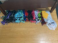 Wide assortment of colorful lanyards spread on the floor along with yellow and clear envelopes.