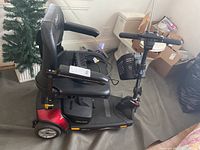 Side view of scooter showing seat, armrests, base, rear wheels and visible scratches