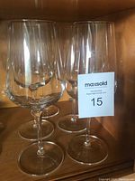 Five clear Luigi Bormioli wine glasses standing together showing overall shape and size.