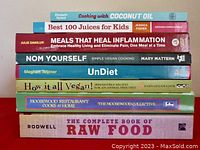 Cookbooks stacked vertically showing the spines with titles and authors.