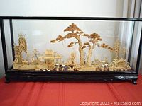 Full view of large vintage Chinese cork diorama inside glass and wood lacquer frame, displayed on red surface.
