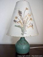Lamp with visible pressed flower botanical shade, unlit, showing natural colors and leaf pattern pottery base.