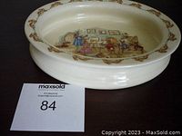 Oblong bone china dish with Bunnykins art class scene inside and rabbit border on rim, side angle view.